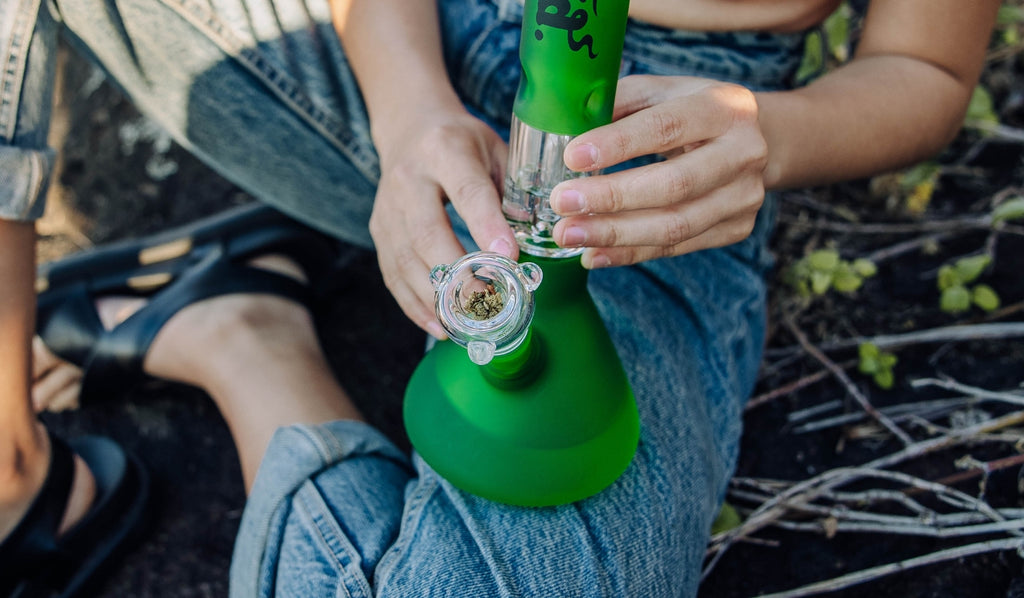 A glass cone piece and bong filled with cannabis