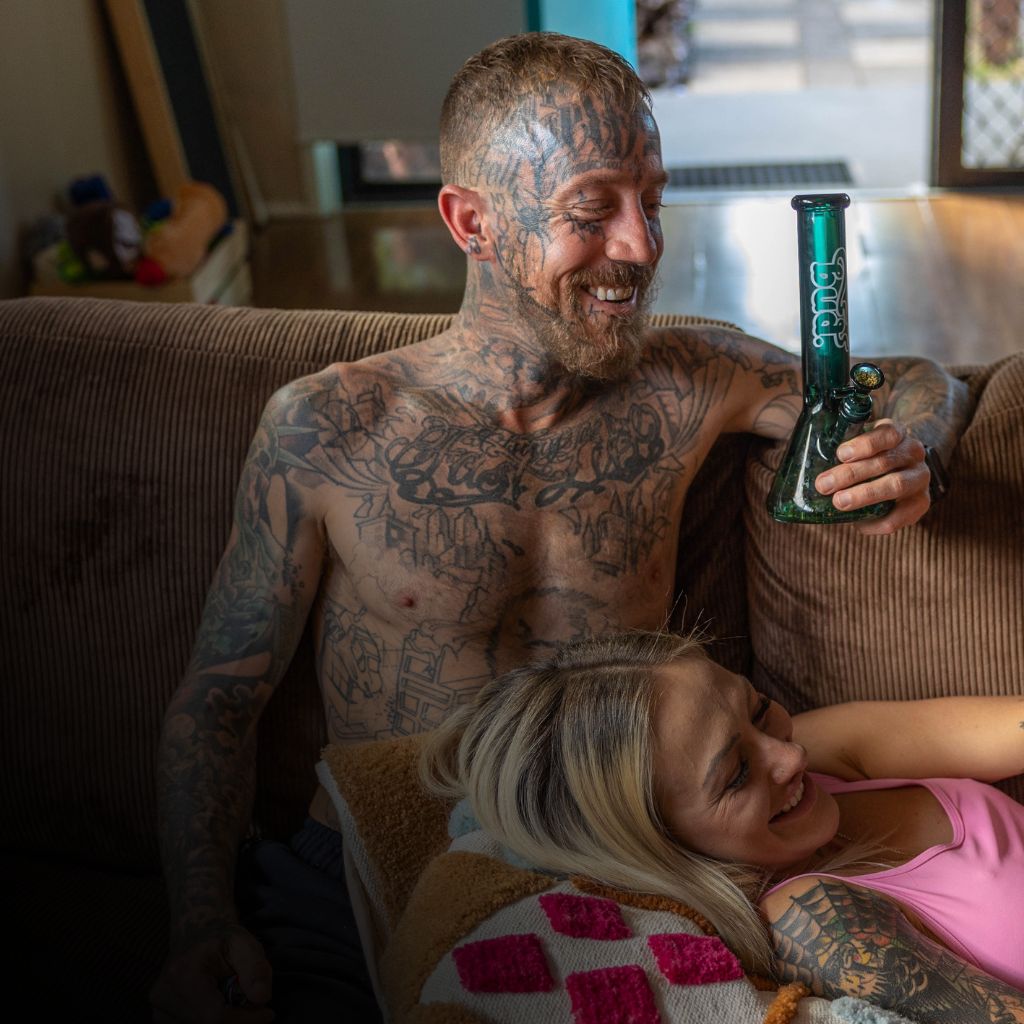 Man holding Bud Beaker Bong on couch