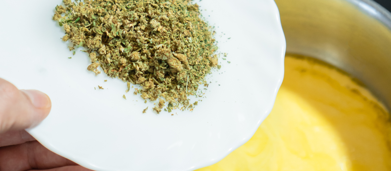 Pouring ground cannabis into butter