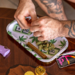 A person rolling a hemp wrap with a rolling tray