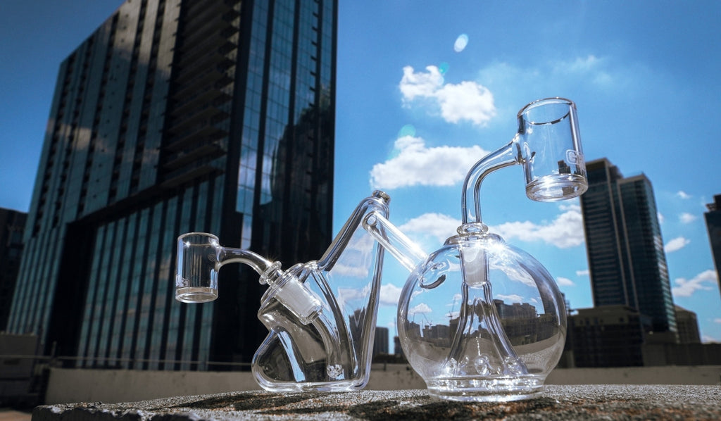 Two glass dab rigs in front of a skyline