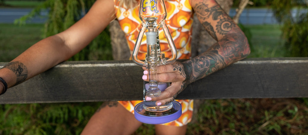Woman holding glass percolator bong