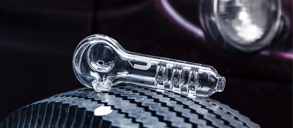A clear glass spoon pipe on a tyre