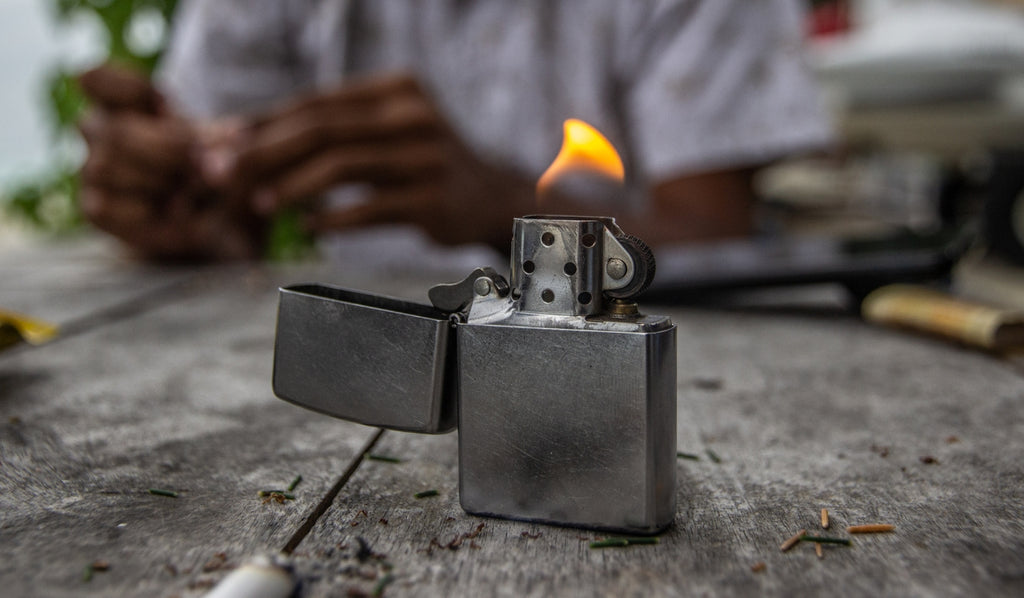 A lit Zippo lighter on a table