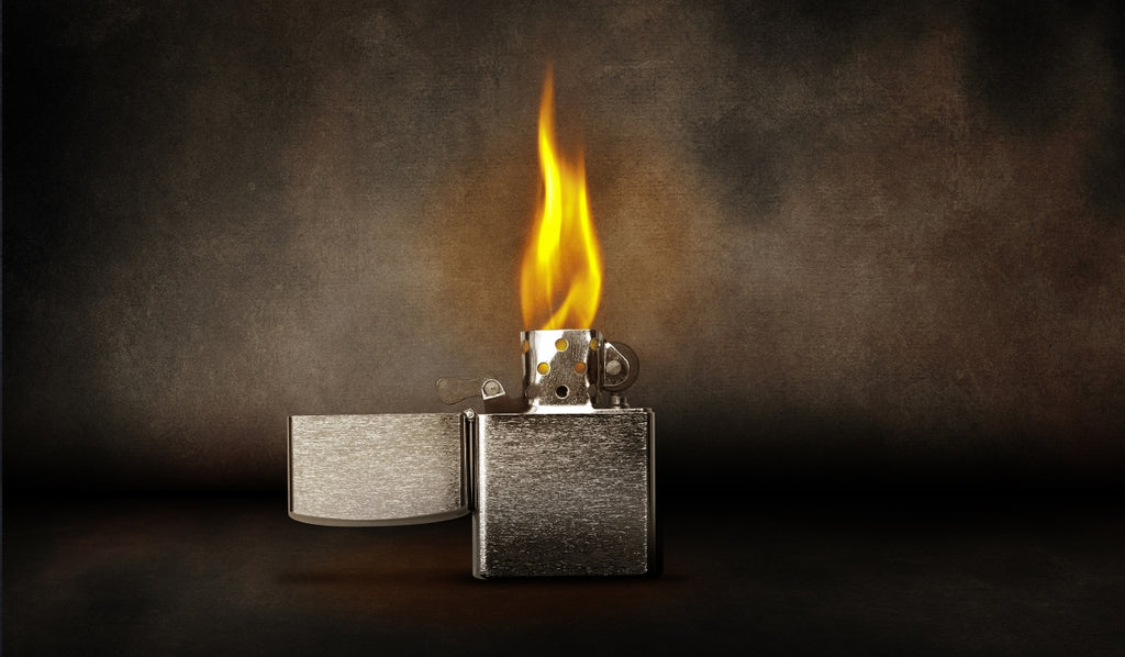 A lit Zippo lighter with a large flame