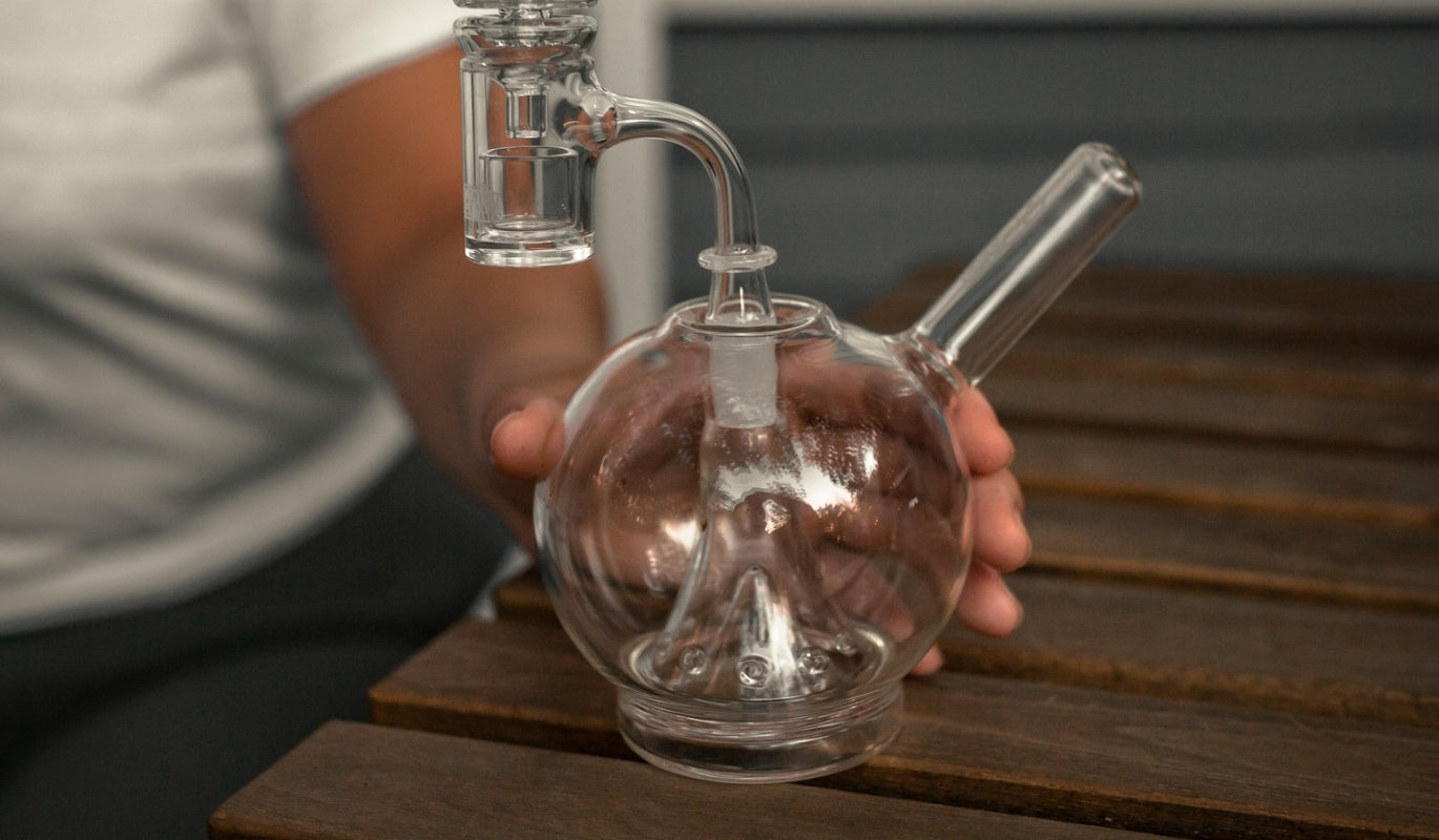 A person holding a GRAV globe bubbler bong