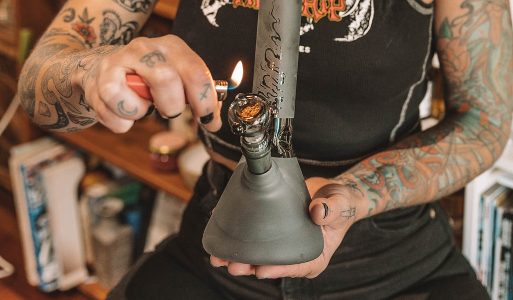 A person lighting a bowl filled with cannabis