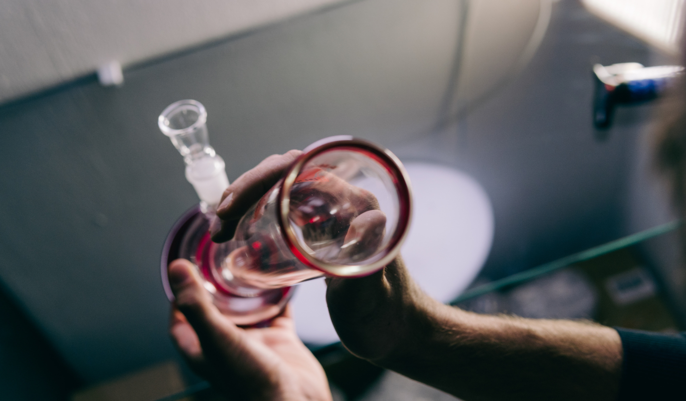 A person looking at the downtube of a bong