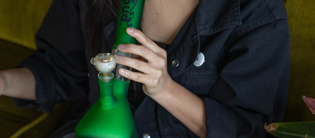 A person smoking from a glass bong