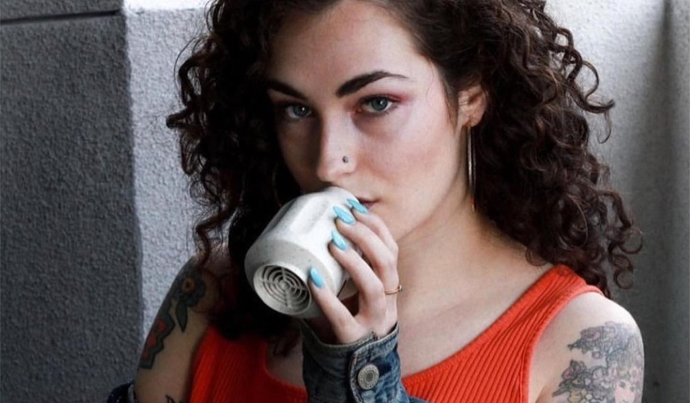 A woman exhaling into an ECO Smoke Buddy Personal Air Filter