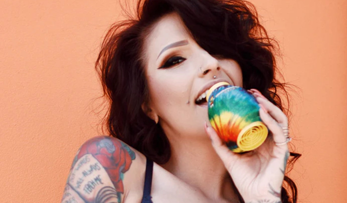 A woman exhaling through a Tie Dye Smoke Buddy Personal Air Filter