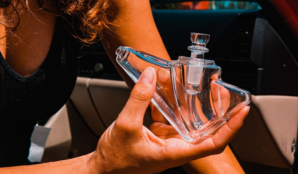 A woman holding a glass bubbler bong