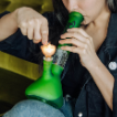 Woman lighting a glass bong with a percolator