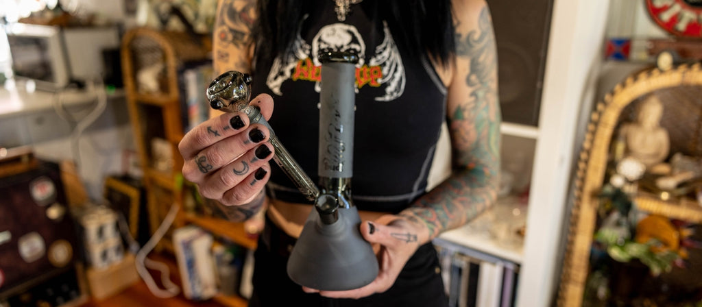 Woman inserting a black diffusor downstem into a Matte Black Bud Beaker Bong 