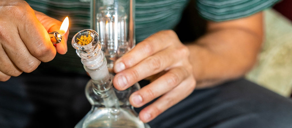 Person lighting a bowl in a bong