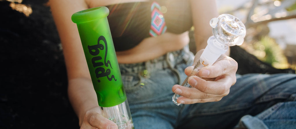 Woman holding a diffusor downstem and a Bud Fluoro Tree Percolator Bong