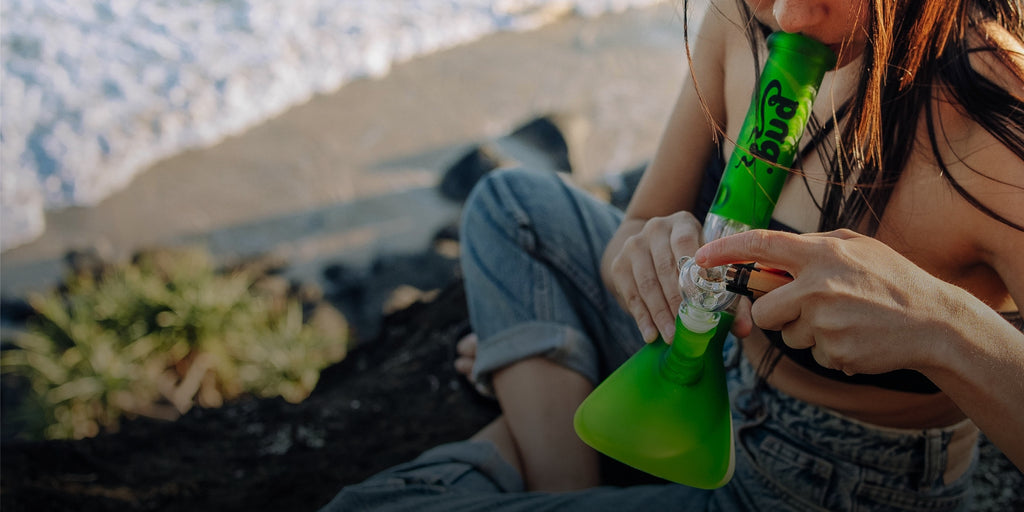 Woman smoking Bud Tree Percolator Bong on beach