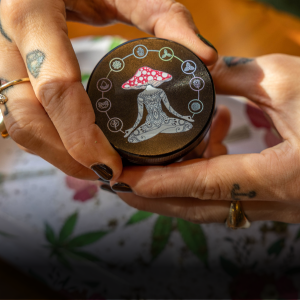 Woman grinding cannabis with a Mushroom Chakra Aluminium 4-Part Grinder 55mm