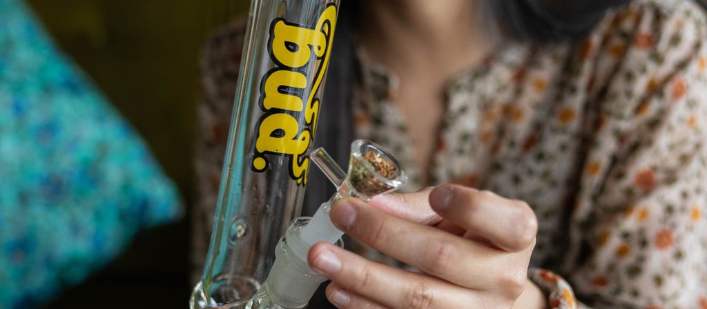 Woman placing a glass cone piece in bong