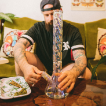 Man with a large glass bong on a table