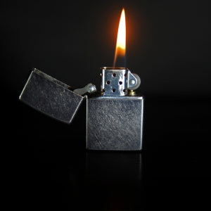 Silver Zippo lighter with a flame
