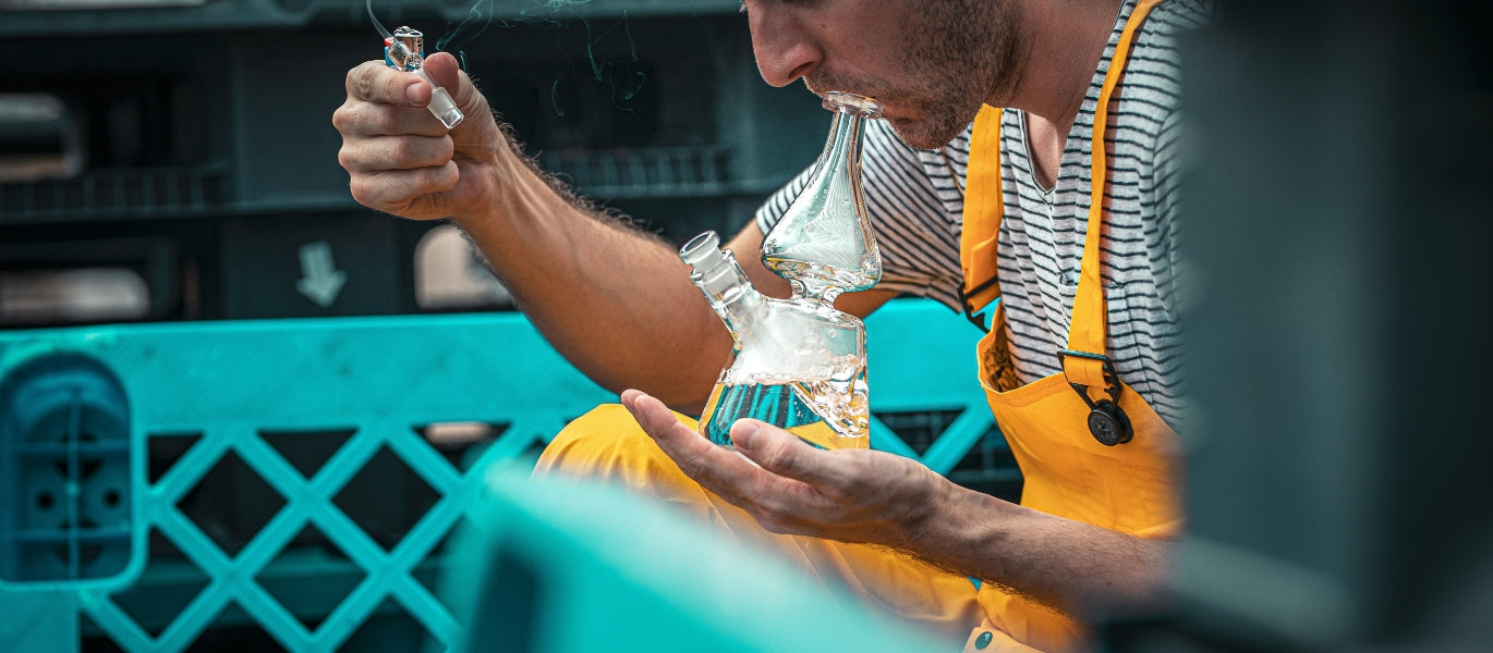 Man inhaling from a glass bong