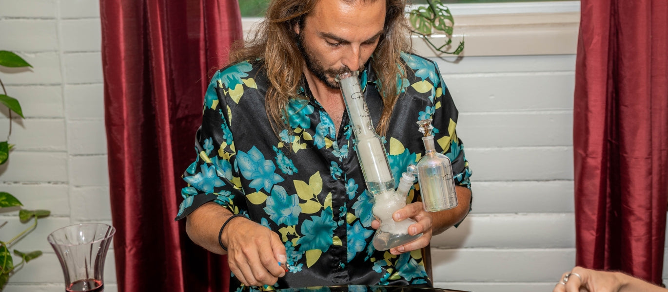 Man smoking bong with percolator ash catcher