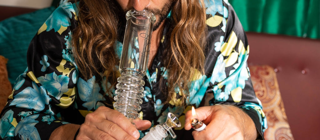 Man smoking from a glass beaker bong