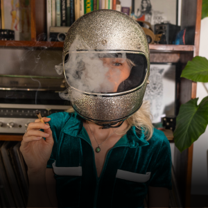 Woman smoking a joint while wearing a retor motocycle helmet