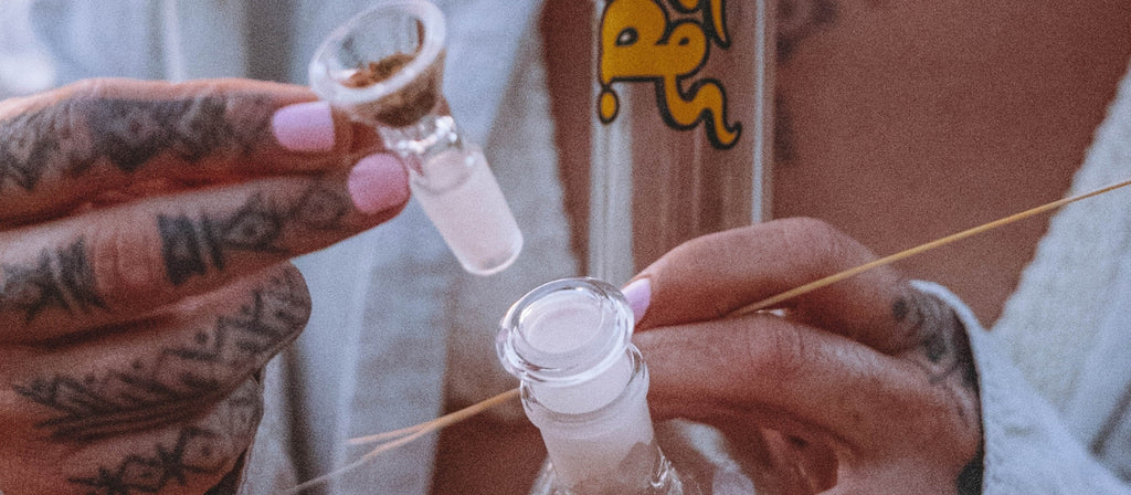 Person inserting bowl into bong