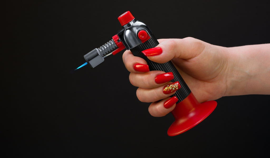 Person holding a red and black jet lighter