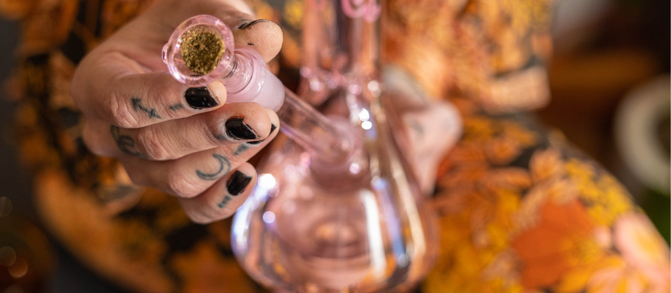 Person inserting cone piece and downstem into glass bong