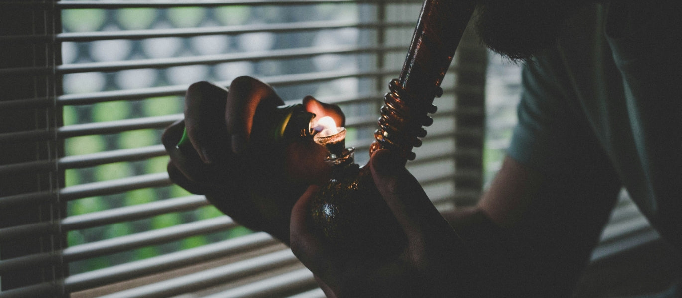 Person lighting and smoking a bong