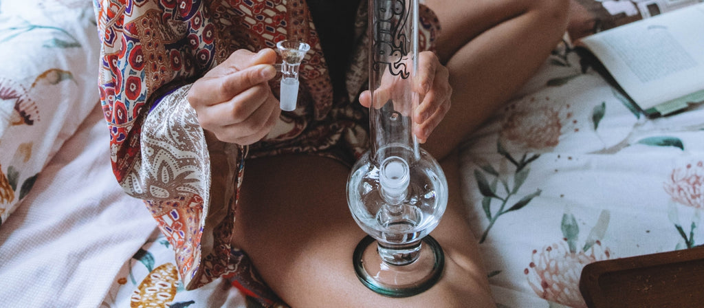 Person removing cone piece from glass bong