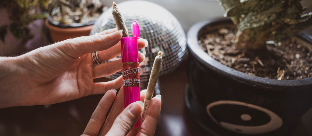 Woman holding a pre-rolled joint and storage tube