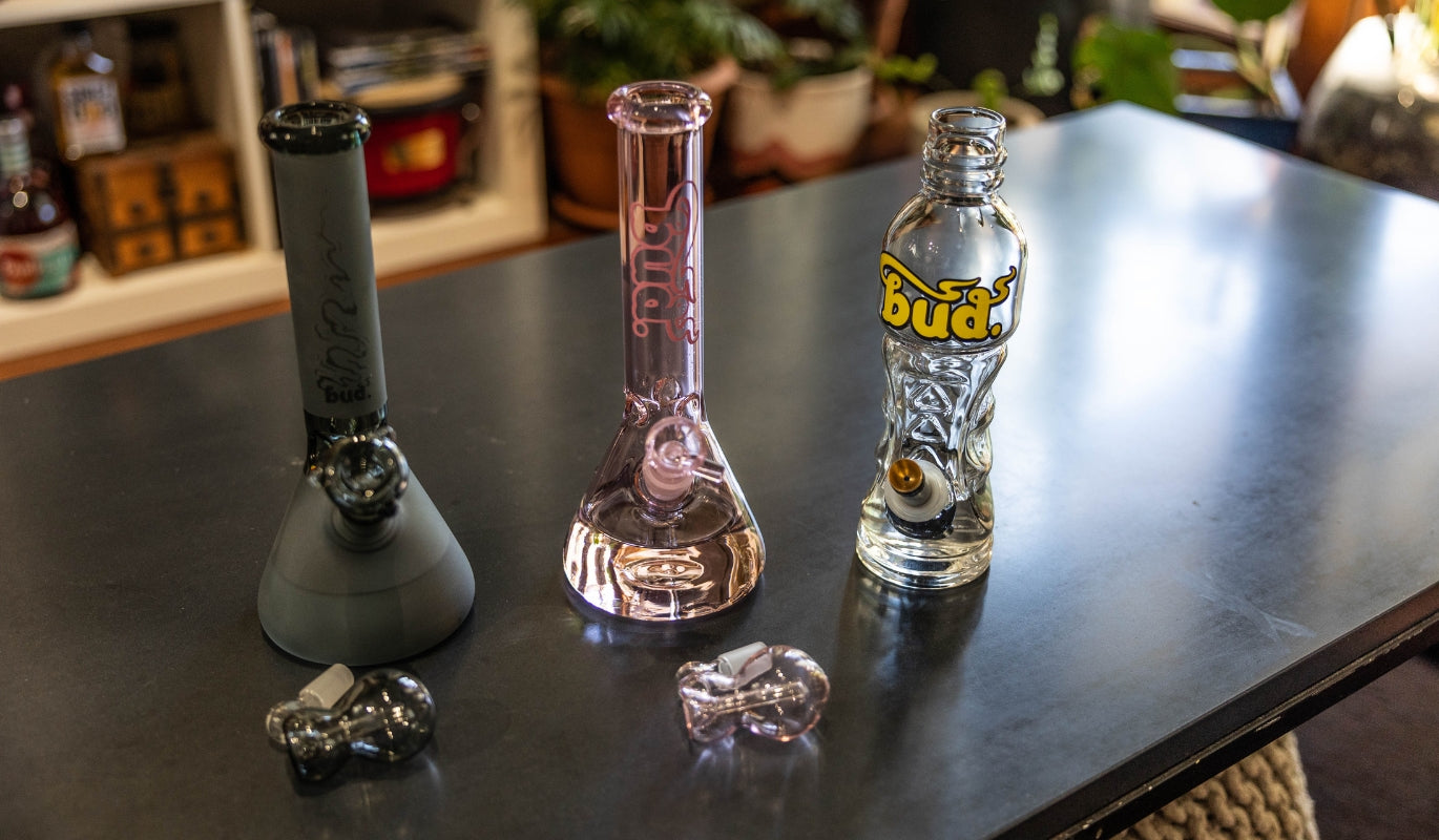Three unique types of glass bongs on a table
