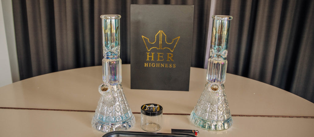 Two Her Highness glass bongs on a table
