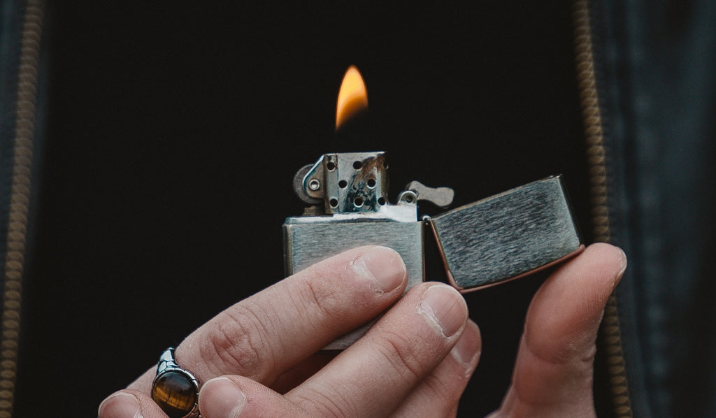 Two hands holding a Zippo lighter