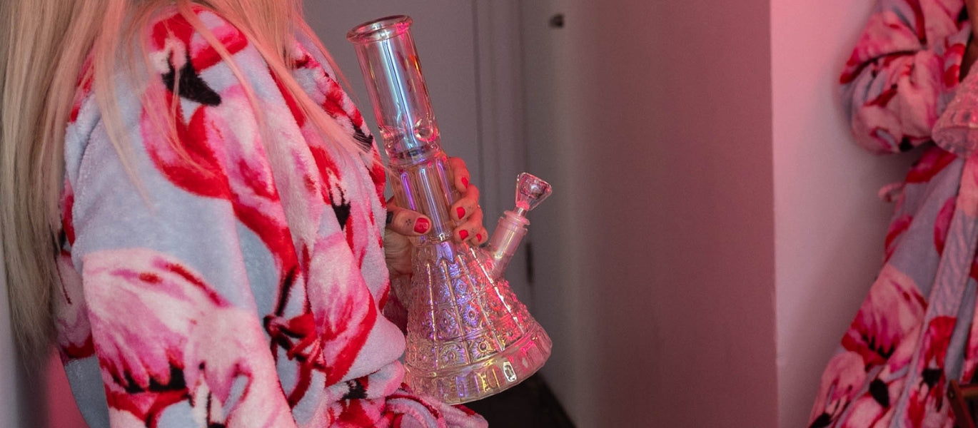 Woman holding glass beaker bong