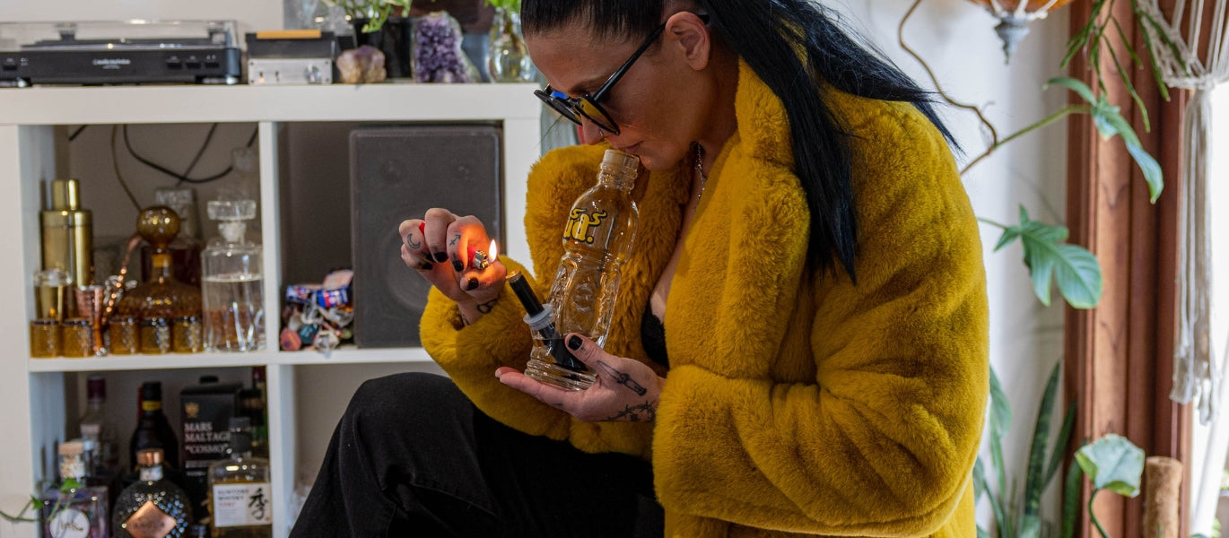 Woman lighting a glass bottle bong
