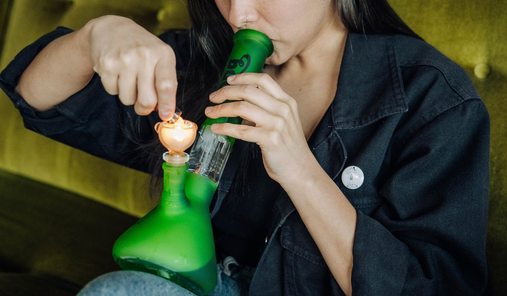 Woman lighting green Bud Percolator Bong