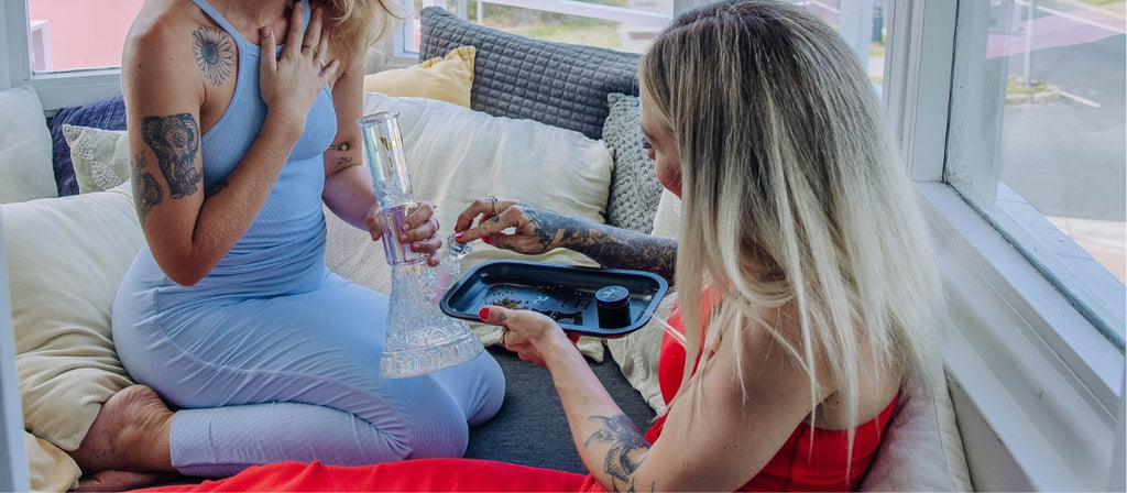 Woman packing a Her Highness glass bong with cannabis