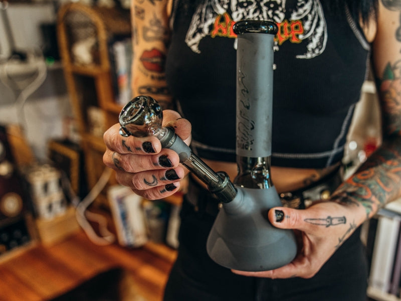 Woman inserting cone piece and downstem into glass bong